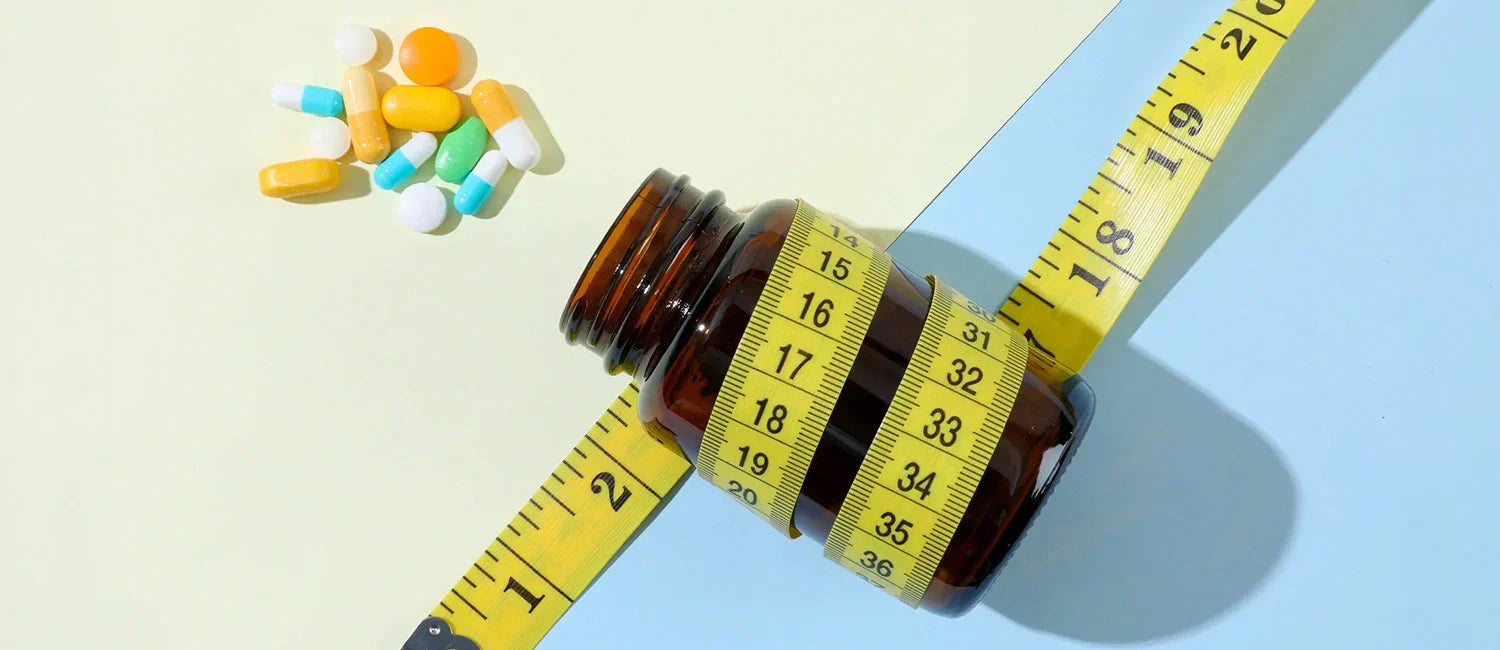 Weight loss pills and measuring tape concept for metabolism and fat loss support